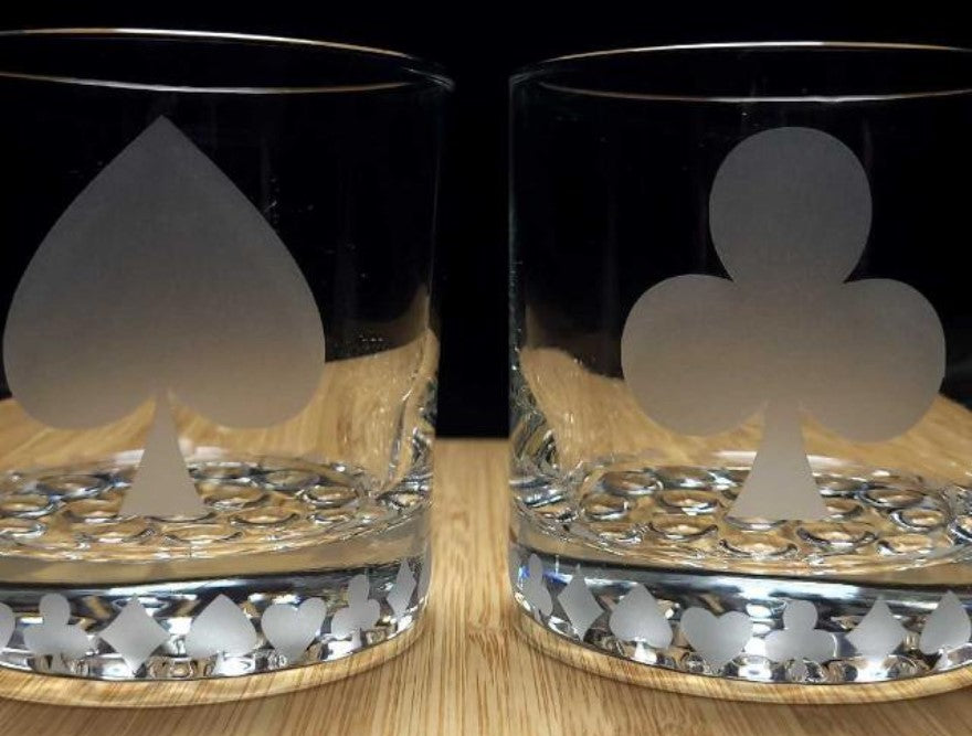 Set of cocktail glasses etched with spade and club card suit designs, perfect for poker nights and card game lovers.